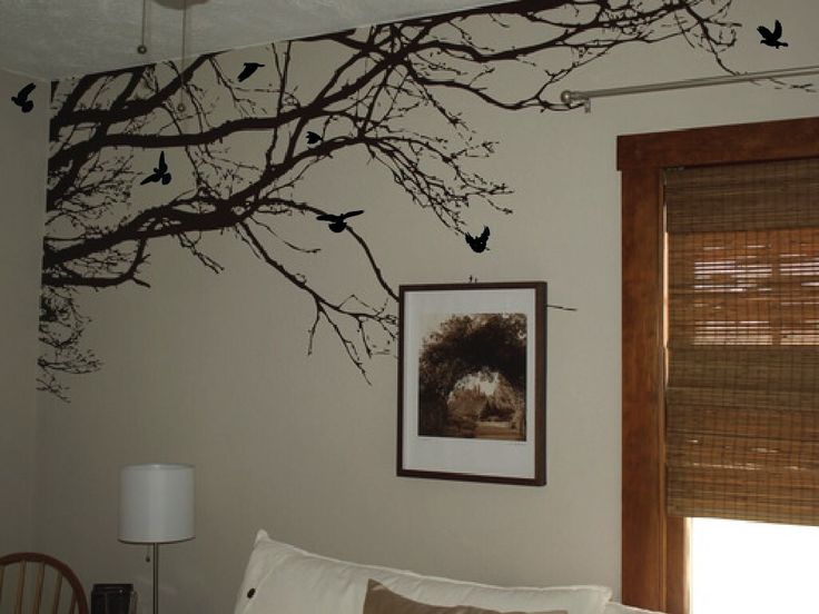 a living room with birds on the tree branch wall decal above the couch and window