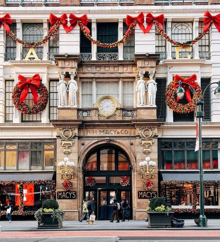 people are walking in front of a building decorated for christmas