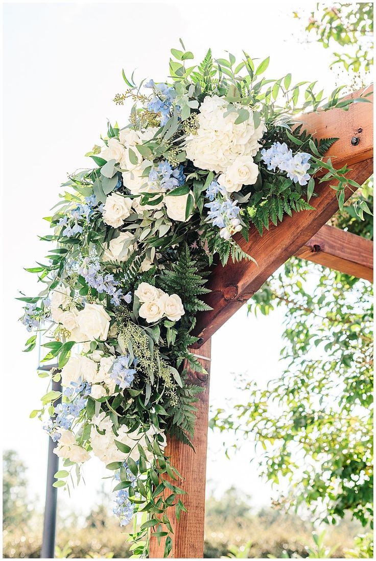 a wedding arch with flowers and greenery on the top is ready for guests to arrive