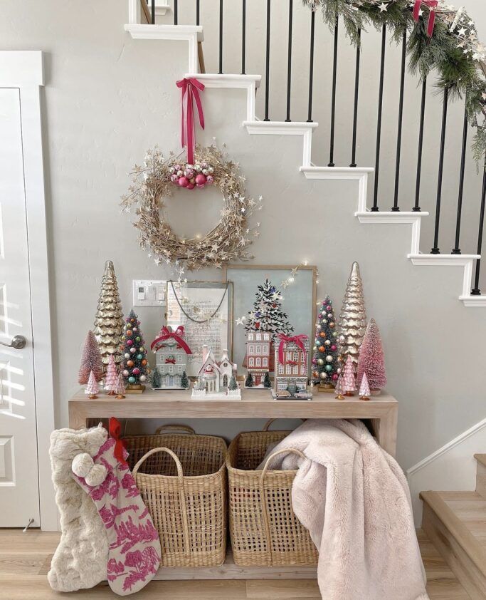 christmas decorations on the stairs and in baskets next to a table with stockings, wreaths and other items