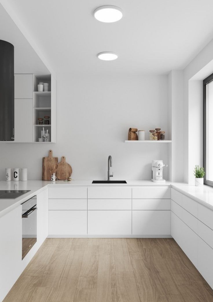 a kitchen with white cabinets and wooden floors