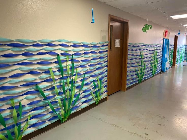 an office hallway decorated with blue and green wall paper, grass and seaweeds