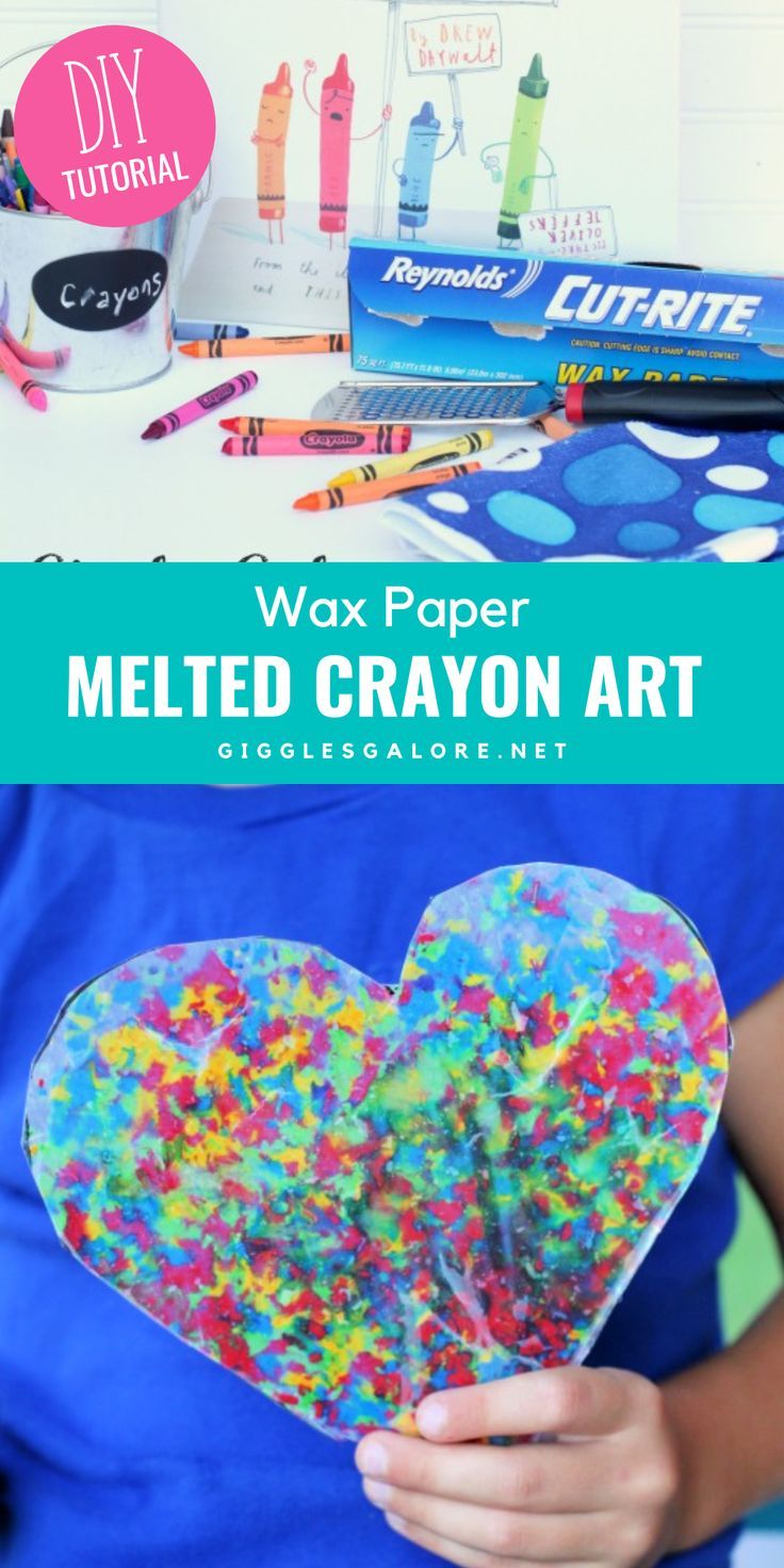 the melted crayon heart is being held in front of a desk with supplies on it