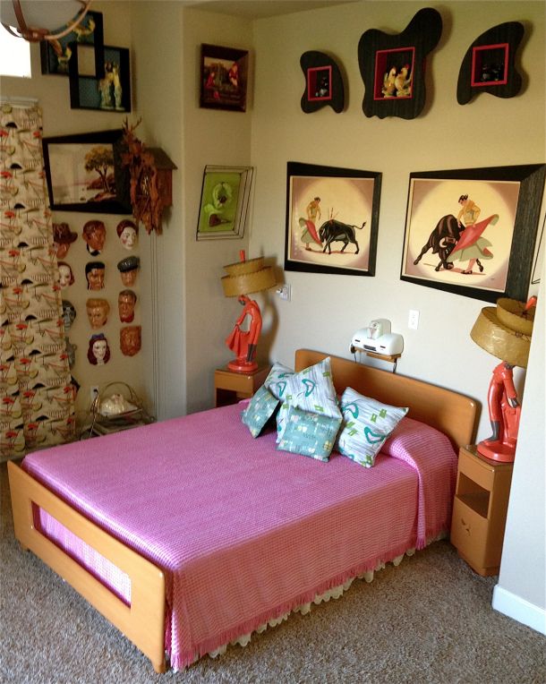 a bed room with a neatly made bed and pictures on the wall