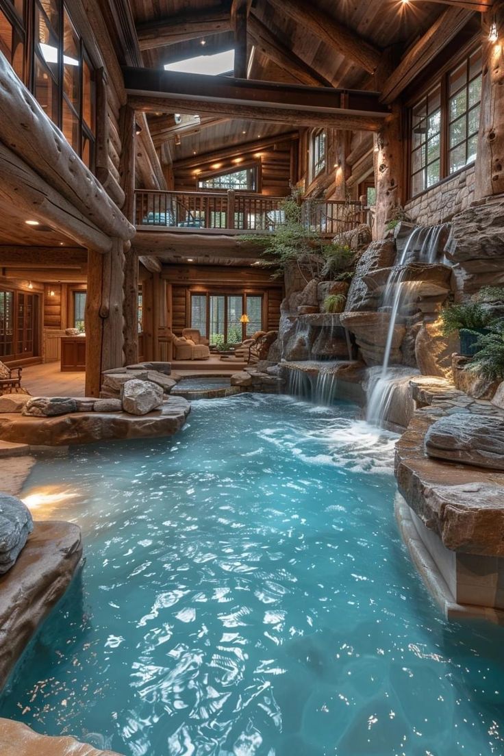 an indoor swimming pool with waterfall in the middle