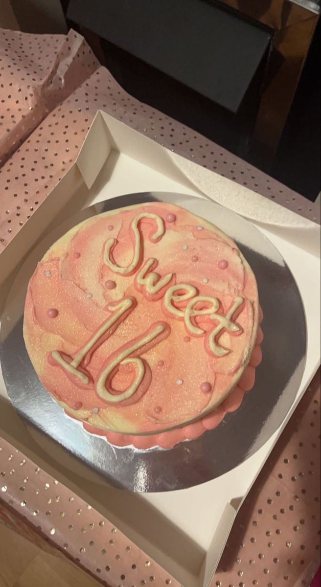 a cake in a box with the word sweet 16 on it's bottom and an orange frosting that says sweet 16