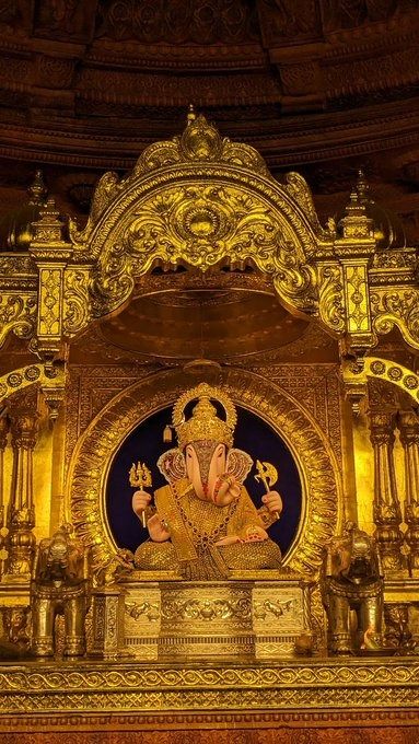 the golden statue is on display in front of an ornately decorated wall and ceiling