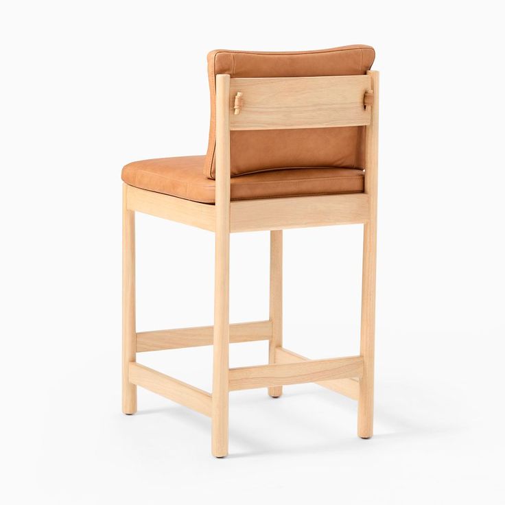 a wooden chair with brown leather seat and backrests on a white background, side view