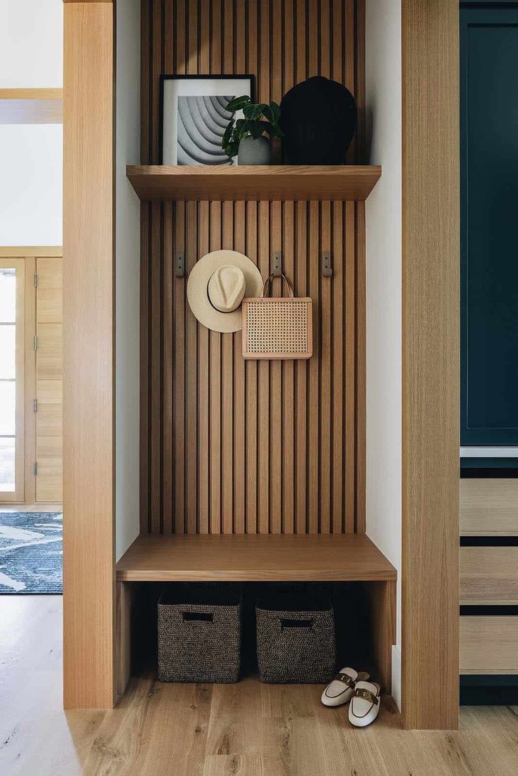 there is a hat and shoes on the shelf in this entryway with wood paneling