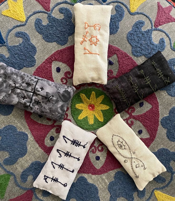 four pairs of socks with different designs on them sitting on top of a colorful rug