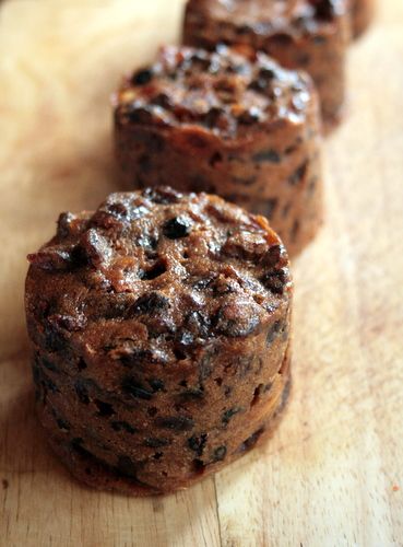 three chocolate muffins sitting on top of a wooden cutting board