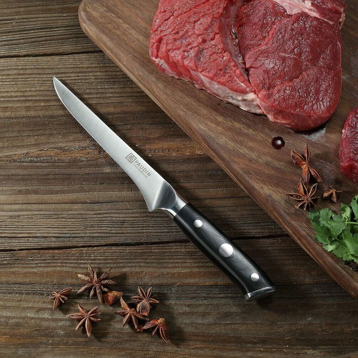 raw meat on cutting board next to knife and star anise