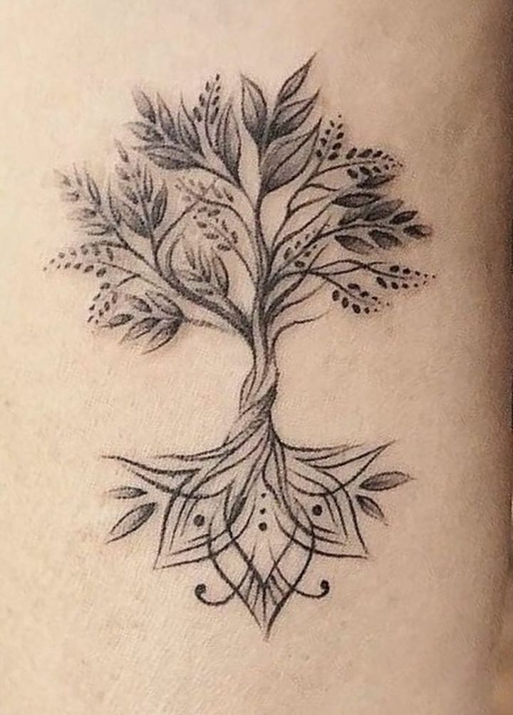 a woman's thigh with a tree tattoo on it