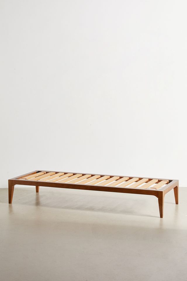 a wooden bed frame sitting on top of a white floor