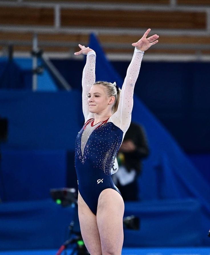 a woman in a blue and white leotard doing gymnastics