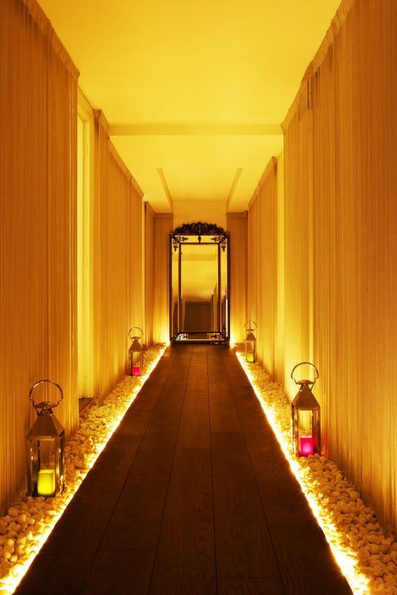 a long hallway with lanterns and lights on either side of the corridor is lit up