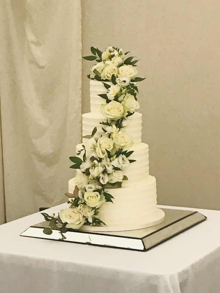 a wedding cake with white flowers and greenery