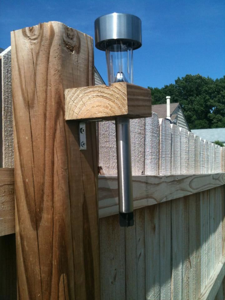 a light that is on top of a wooden fence