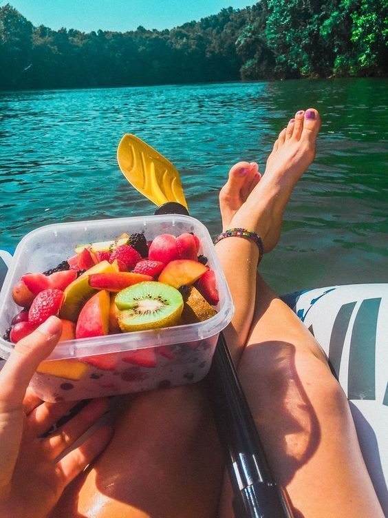 a woman is sitting on a boat with fruit in her lap