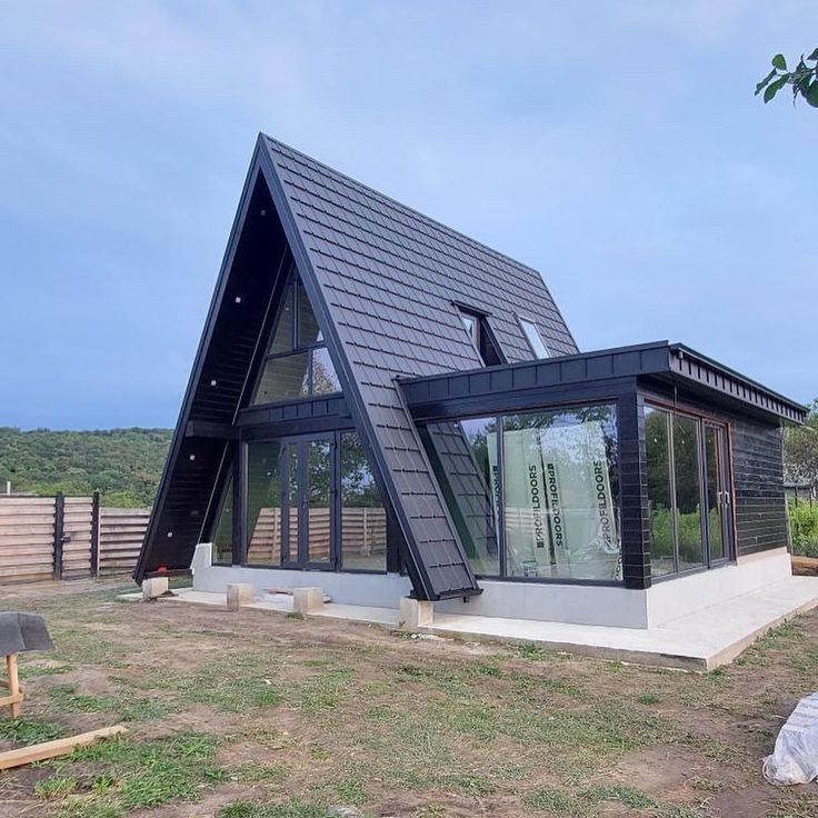 a black and white house sitting on top of a grass covered field