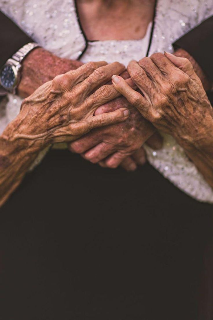 an older woman holding her hands together