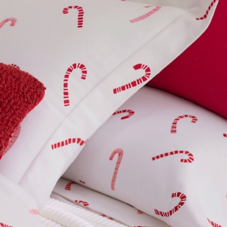 a bed with candy canes on it and red pillows