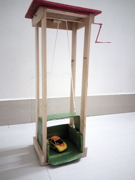 a toy car in a wooden box on top of a floor next to a wall