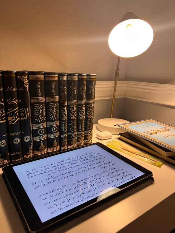 a tablet sitting on top of a desk next to books