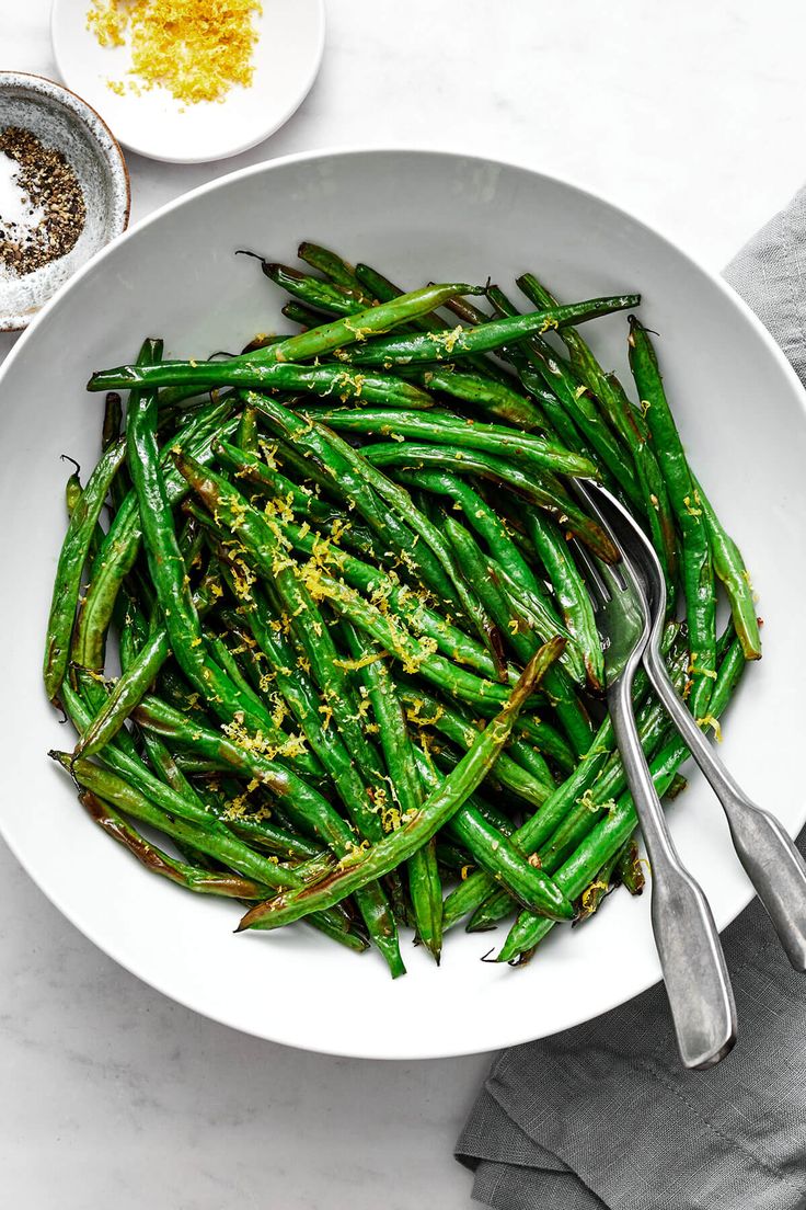 a white bowl filled with green beans and seasoning