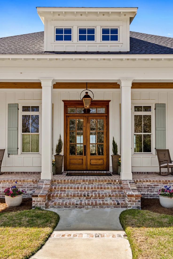 a white house with two front doors and steps leading up to it