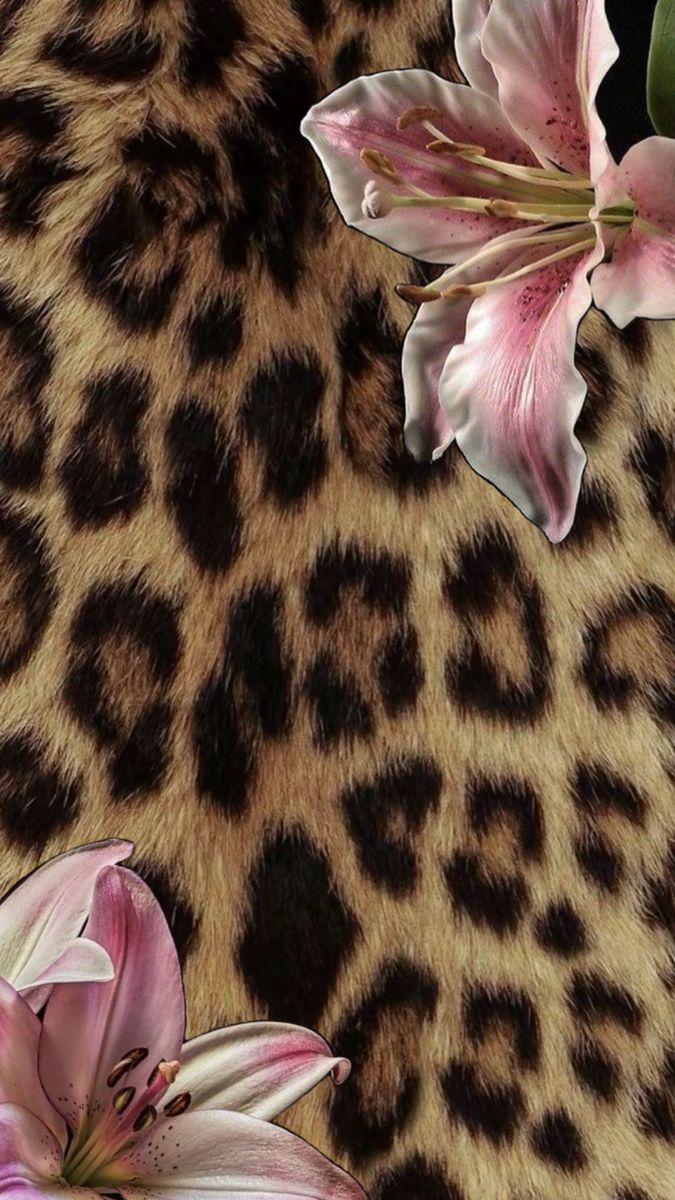 two pink flowers sitting on top of a cheetah print fabric with leopard spots