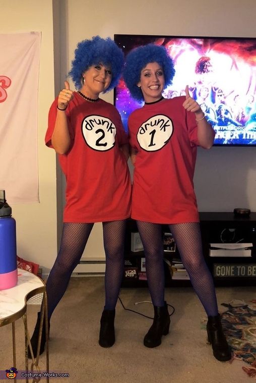 two women dressed in red shirts and black stockings posing for the camera with their thumbs up