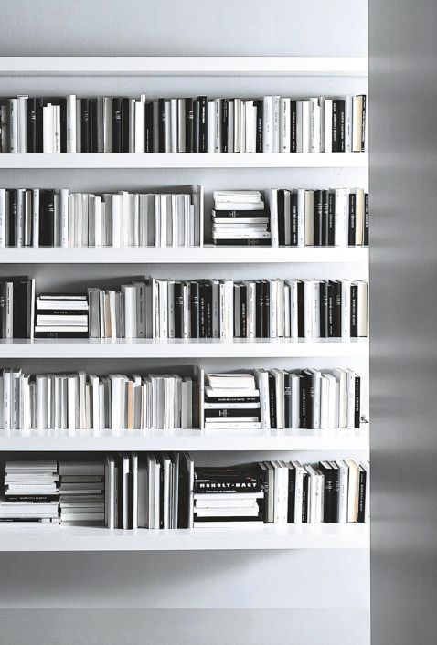 a white book shelf filled with lots of books