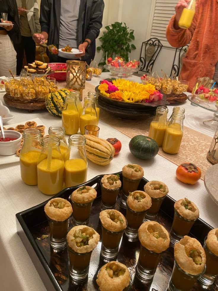 a table filled with food and drinks on top of a white tablecloth covered table