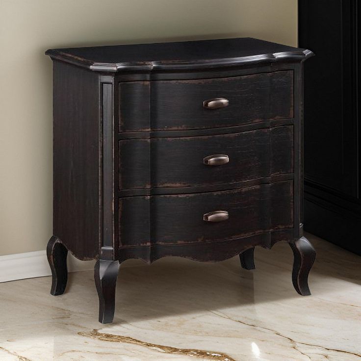 an old black wooden dresser with three drawers