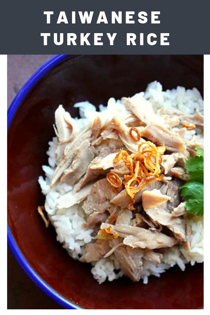 a bowl filled with rice, meat and garnishes on top of it