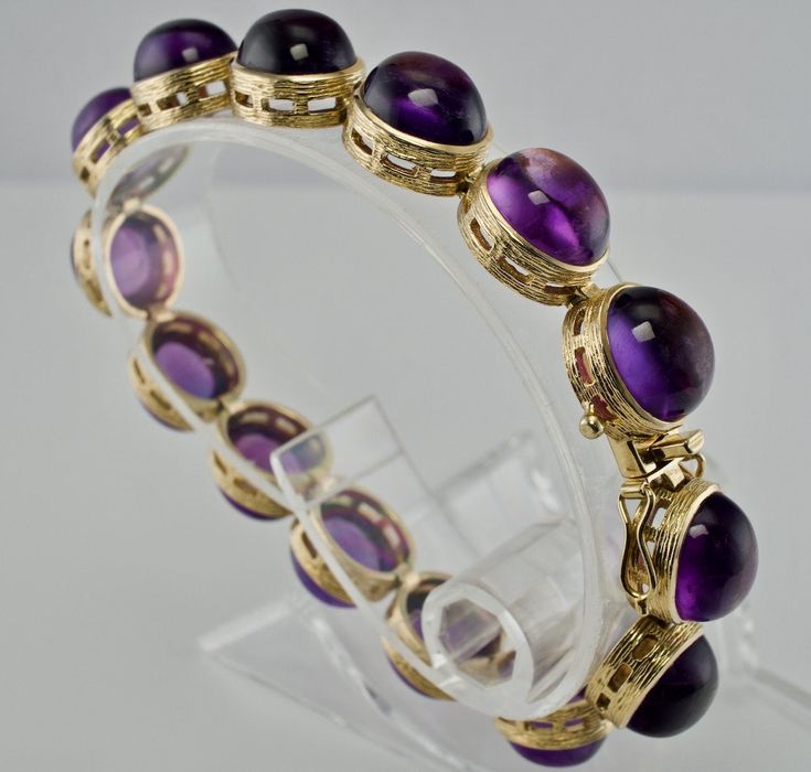 Genuine Amethyst Bracelet, Natural Amethyst, February Birthstone, Elegant Bracelet, Purple Bracelet, 14K Gold Bracelet, Vintage Bracelet, Everyday Bracelet, Purple Amethyst, Amethyst Cabochon Bracelet. This gorgeous estate bracelet is finely crafted in solid 14K Yellow Gold and it is set with genuine Earth mined Amethyst cabochons. Each gem is 10mmx 8mm for the total weight of (32.06cttw) These cabochons are of great quality and good intensity. The bracelet is 7 inches long and 8mm thick. The br Antique Round Gemstone Bracelets, Antique Gemstone Bracelets, Luxury Round Amethyst Bracelets, Yellow Gold Cabochon Bracelets For Weddings, Formal Purple Fine Jewelry Bracelet, Elegant Amethyst Bracelet, Collectible Hallmarked Bracelets, Formal Round Amethyst Bracelets, Formal Amethyst Bracelets