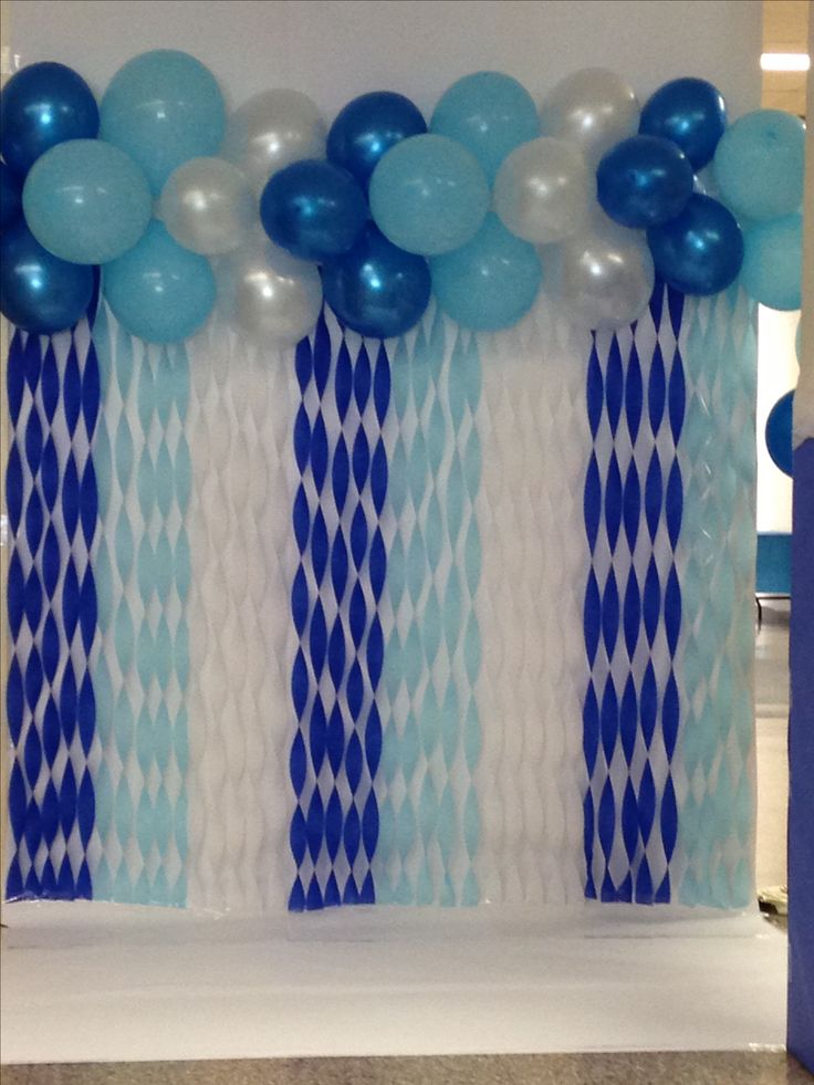 blue and white balloons are on display in front of the backdrop for a birthday party