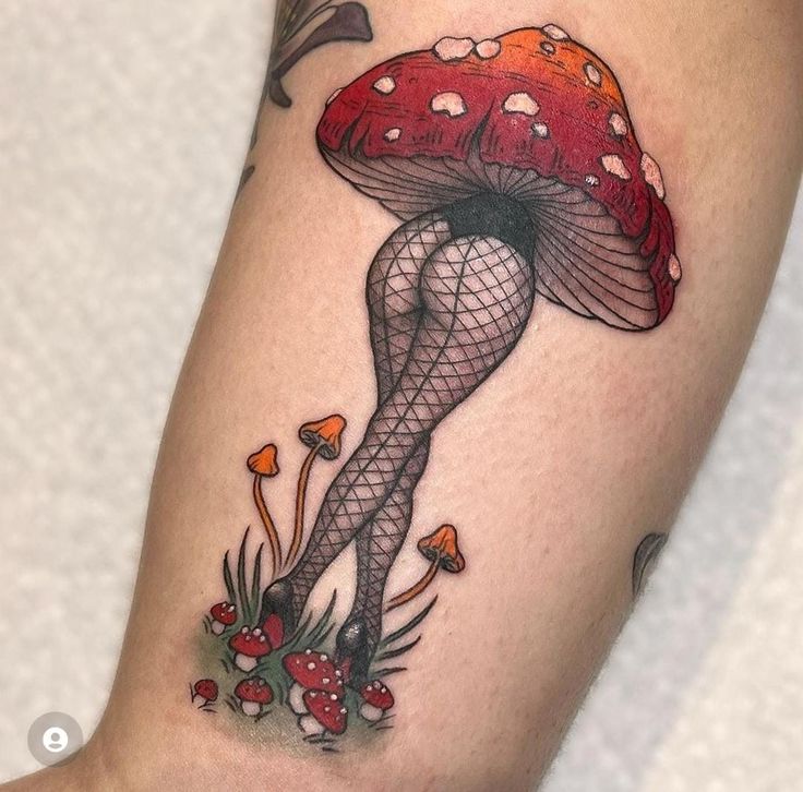 a woman's leg with a mushroom tattoo on her thigh and legs in fish net stockings