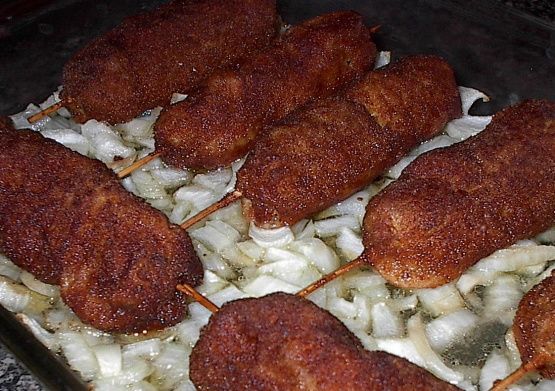 chicken skewers with onions and cheese in a baking dish on a granite countertop