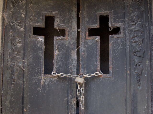 two crosses are chained to the front door