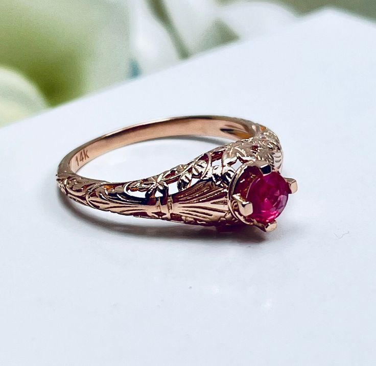 Natural Ruby Gold 14K Rose Gold Ring  Floral Wedding Design#154 This is a Victorian reproduction wedding ring in 10K solid rose gold filigree with a natural red ruby gemstone solitaire. This full cut round gem is 4mm in diameter. The inside of the band is marked 10K for gold. Notice the beautiful floral motif in the gold filigree setting. This is a lovely rendition of an Antique filigree ring.  The original ring was a floral wedding antique ring.  The Edwardian influence gives it more flair and Traditional Oval Filigree Wedding Ring, Traditional Yellow Gold Ruby Wedding Ring, Traditional Yellow Gold Ruby Ring For Wedding, Traditional Oval Ruby Ring For Anniversary, Gold Ruby Ring With Intricate Design For Wedding, Hallmarked Yellow Gold Ruby Ring For Wedding, Yellow Gold Hallmarked Ruby Ring For Wedding, Traditional Oval Ruby Wedding Ring, Traditional Oval Engraved Ring For Wedding