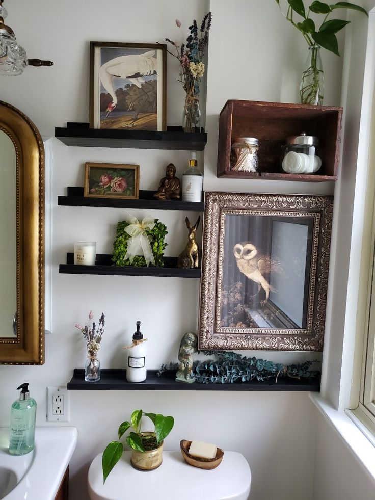 a bathroom with shelves and pictures on the wall