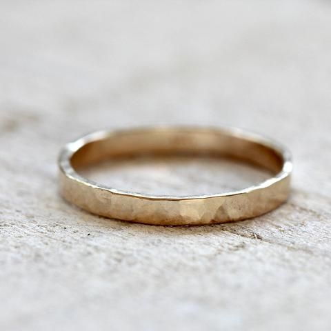 a gold wedding band sitting on top of a stone floor with no one around it