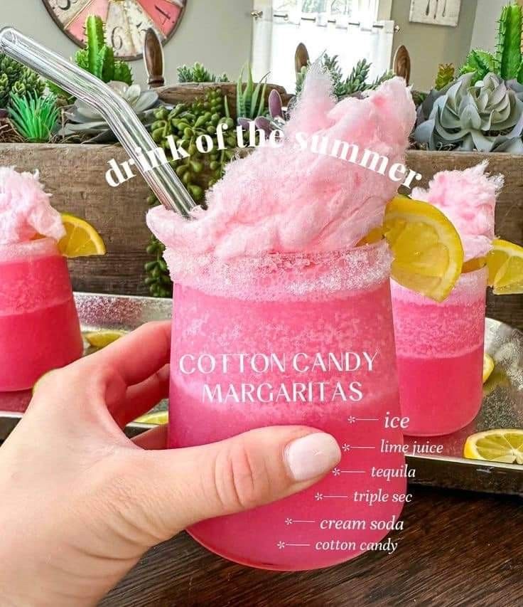 two pink cocktails with lemon wedges and cotton candy