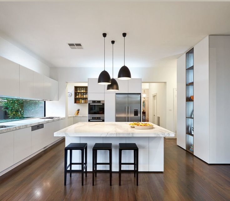 a kitchen with an island and three stools in front of the countertop area