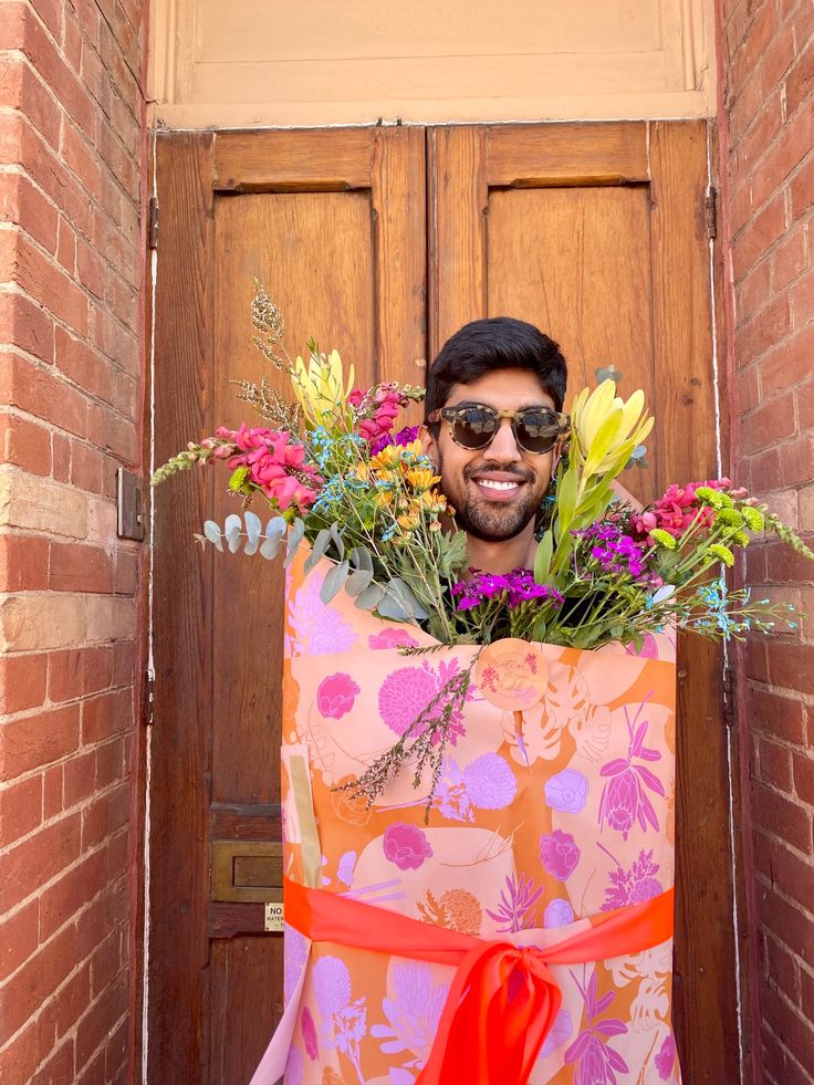 a man is holding a large bag with flowers in it