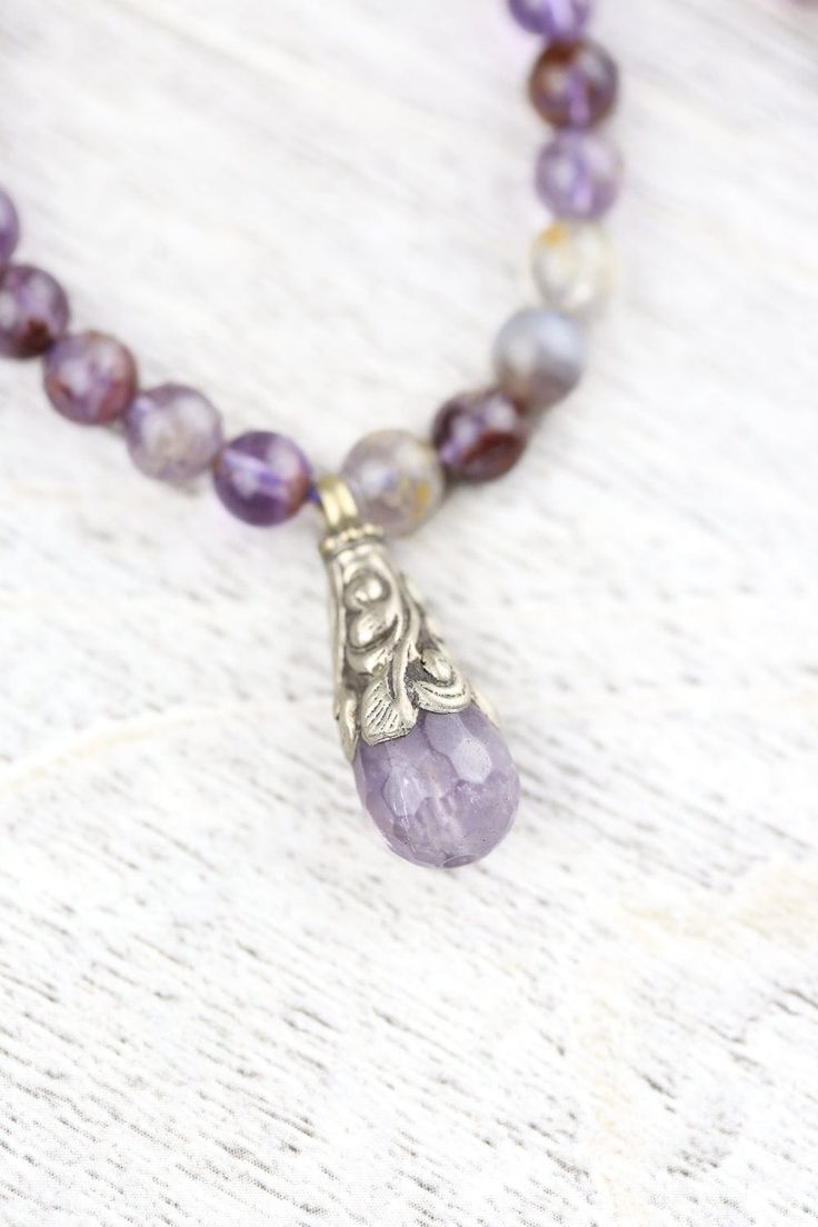 We are so excited to introduce our DharmaShop exclusive Super Seven Mala! Hand strung here in Detroit with genuine Super Seven beads from Brazil and a faceted Amethyst gemstone pendant from Nepal. Super Seven is a rare mineral made from a blend of seven crystals including: Amethyst, Clear Quartz, Smoky Quartz, Cacoxenite, Rutile, Geothite, and Lepidocrocite. This incredibly powerful stone combines the healing properties of all seven crystals! Super Seven is believed to energize and heal all seve Faceted Amethyst Healing Necklace, Lavender Crystal Necklaces With Faceted Beads For Gifts, Lavender Faceted Beads Crystal Necklace Gift, Spiritual Gemstone Pendant Beads, Briolette Gemstone Beads Crystal Necklace For Healing, Briolette Crystal Necklace With Gemstone Beads For Healing, Healing Briolette Gemstone Beads Crystal Necklace, Spiritual Faceted Beads Jewelry For Meditation, Spiritual Amethyst Necklace With Faceted Beads