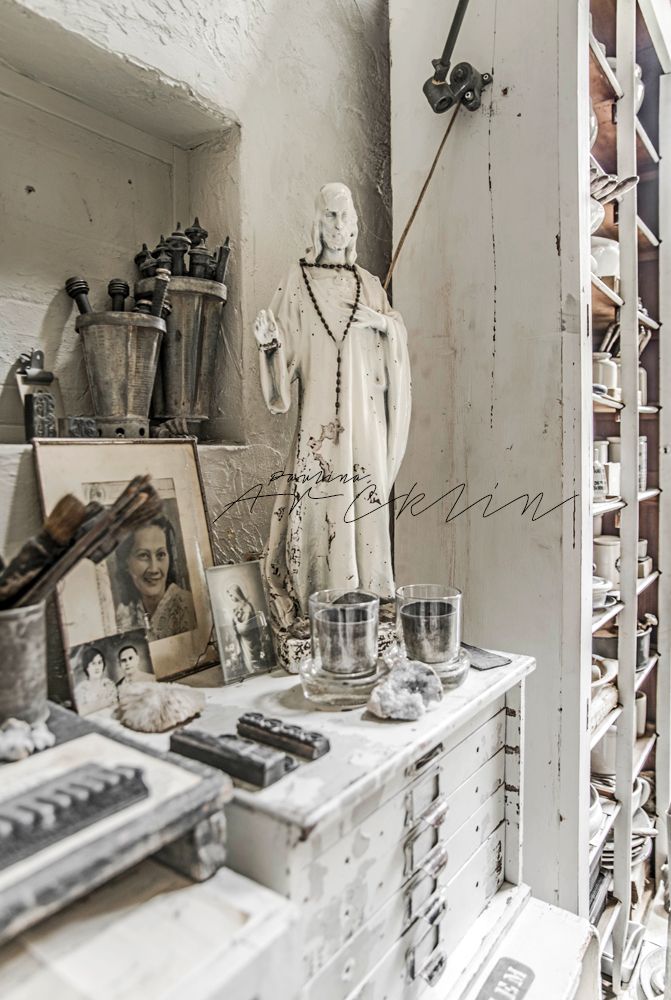 an old dresser with many items on top of it and a statue in the background