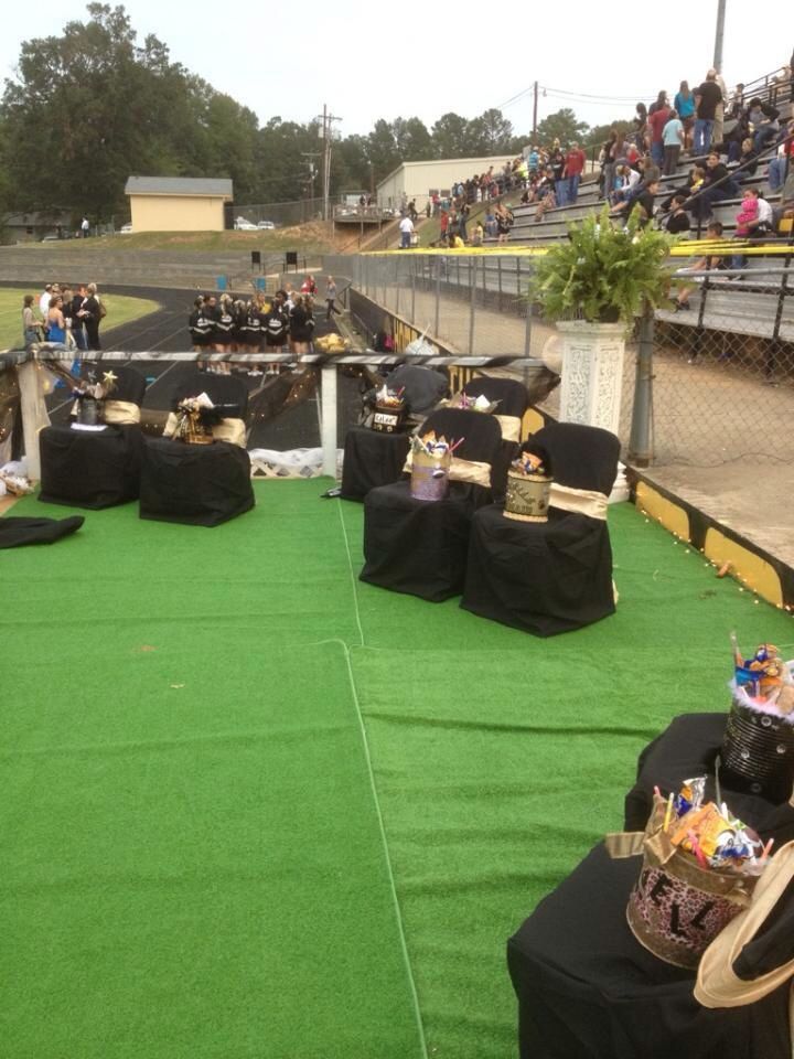 an outdoor event with tables and chairs set up in front of the bleachers